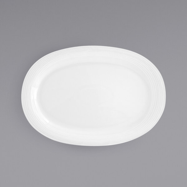 A white oval porcelain platter with a curved edge.