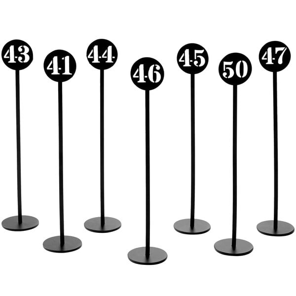 A set of black American Metalcraft table number stands with white numbers.