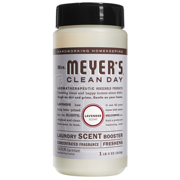 A case of 6 white Mrs. Meyer's Clean Day Lavender Laundry Scent Booster bottles with black lids and red labels on a counter.