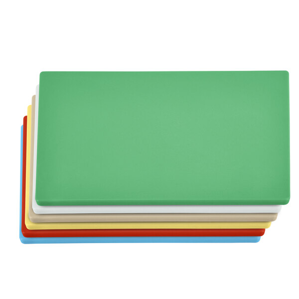 A stack of four colorful plastic cutting boards in green, white, yellow, and red.