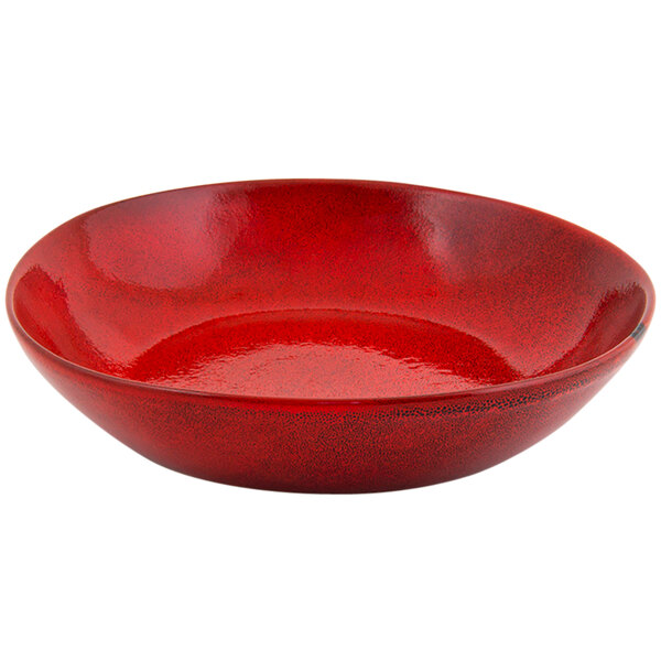 A red porcelain bowl with black specks.