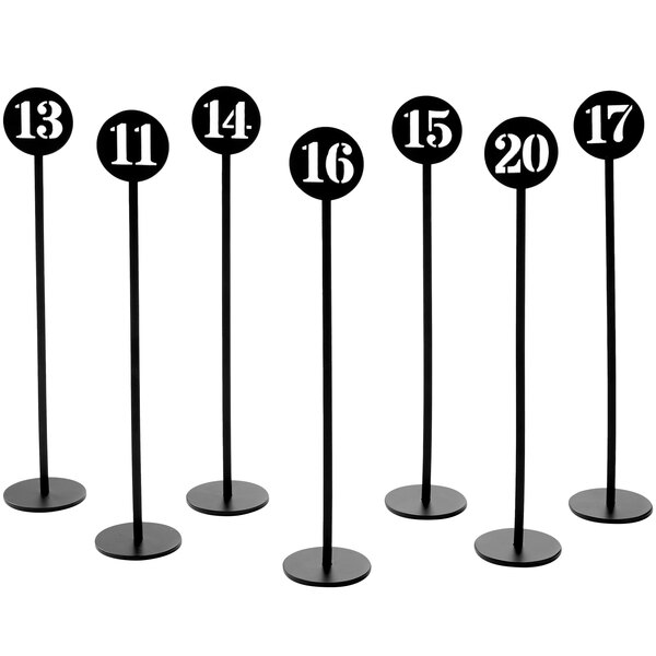 A set of black stamped metal table stands with numbers 11 to 20.
