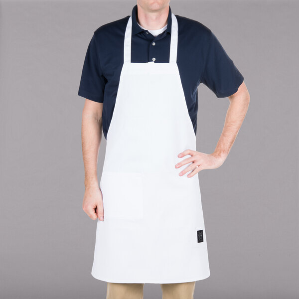 A man wearing a white Chef Revival bib apron with a pocket.