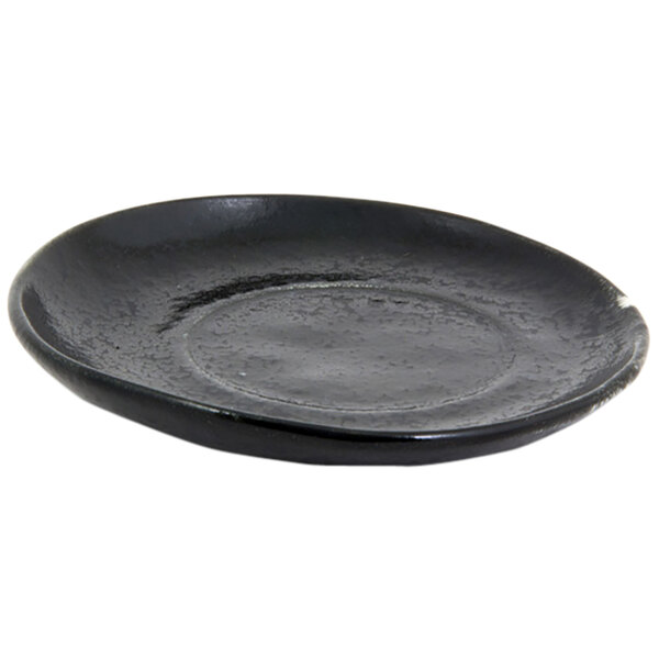 A black porcelain saucer with a circular edge.