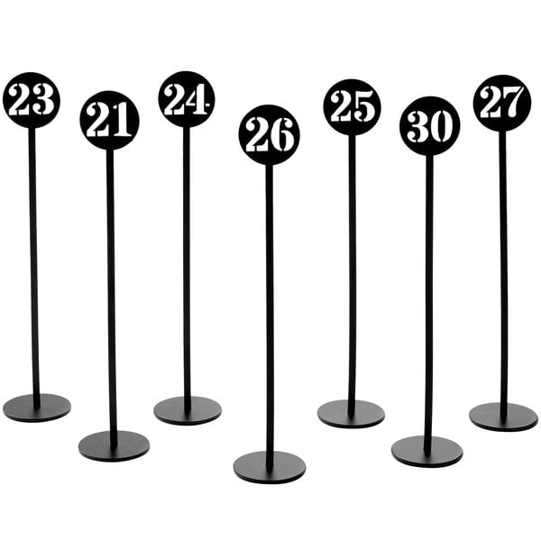 A set of black American Metalcraft table number stands with stamped numbers.