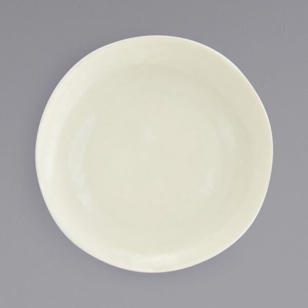 A close up of a Kiln vanilla bean porcelain plate with a small rim.