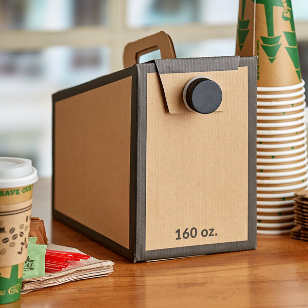 A cardboard box with a lid and handle for beverages on a table.