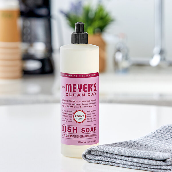 A bottle of Mrs. Meyer's Clean Day Peony Scented Dish Soap on a kitchen counter.