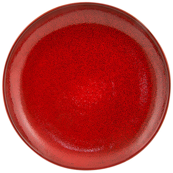 A close up of a red porcelain plate with black specks.
