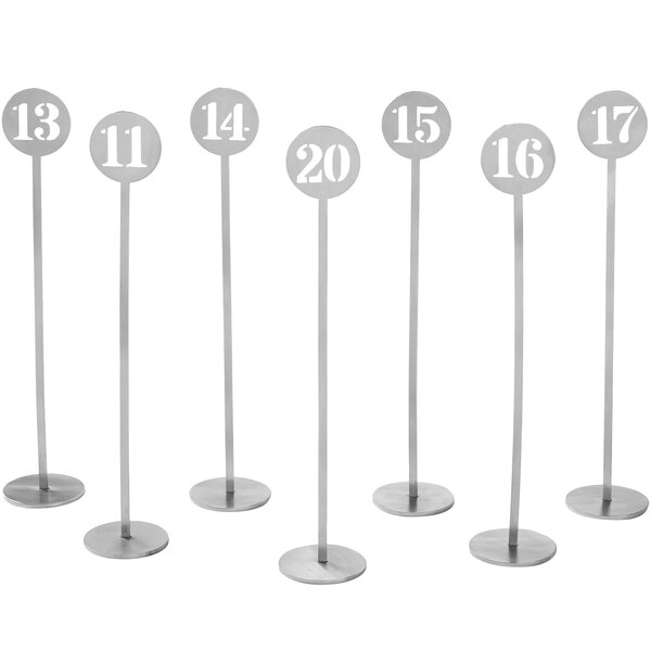 A group of metal American Metalcraft table number stands with numbers.