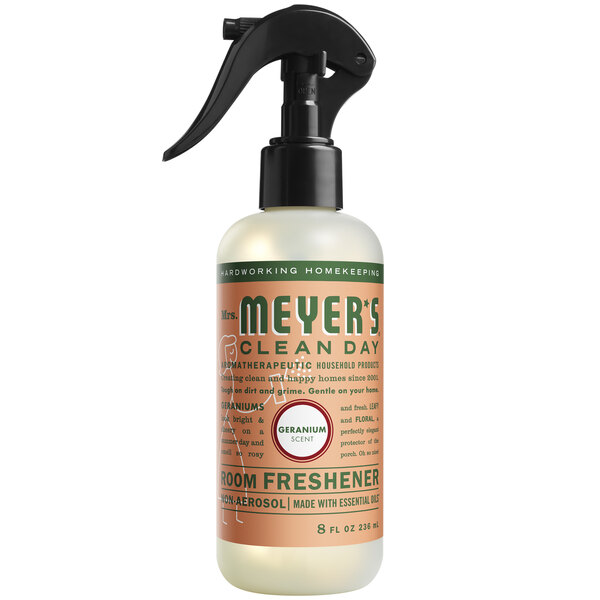 A close-up of a Mrs. Meyer's Clean Day Geranium Air Freshener spray bottle with a black handle.