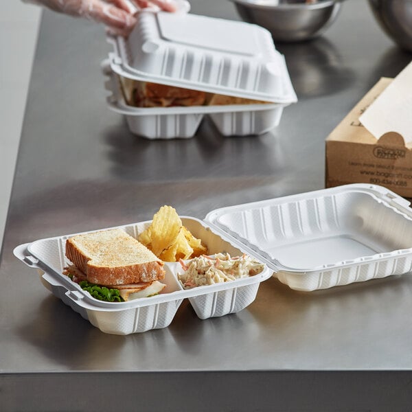 A person using an Ecopax white plastic 3-compartment take-out container to hold food.