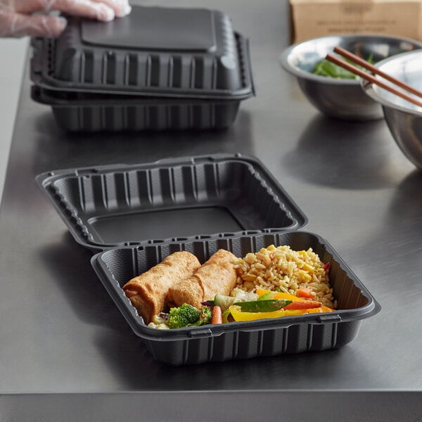 A hand using chopsticks to eat food in an Ecopax take-out container.