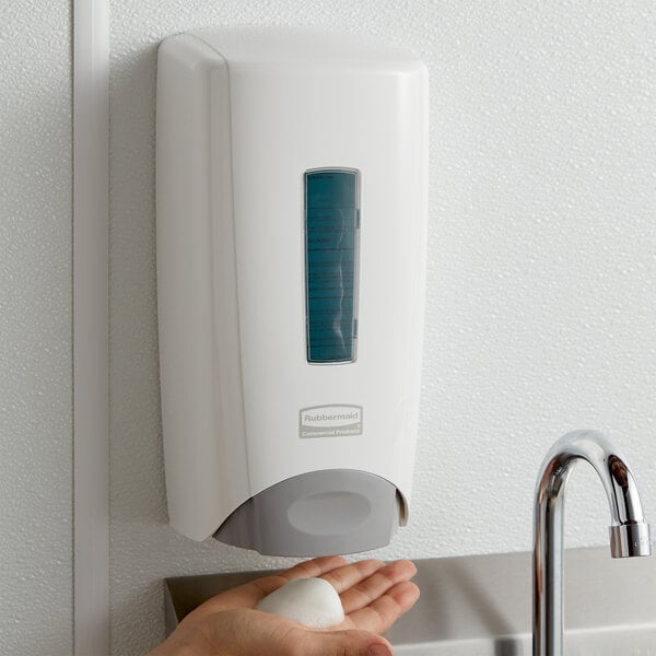 A person using a white Rubbermaid Flex soap dispenser to wash their hands.