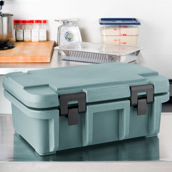 A slate blue Cambro Ultra Pan Carrier on a counter.