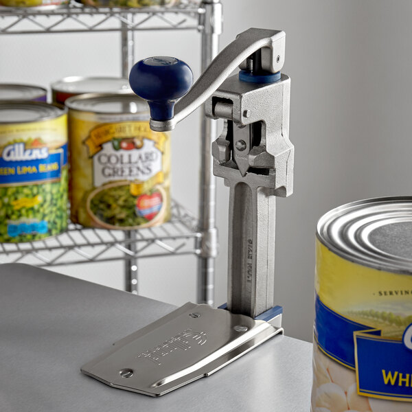 An Edlund Old Reliable #1 Manual Can Opener with a Plated Steel Base on a shelf next to a can.