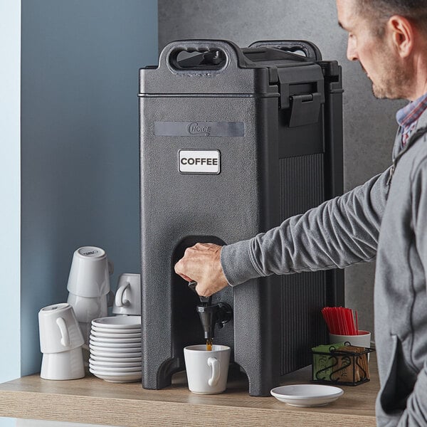 A man pouring coffee into a black insulated beverage dispenser.