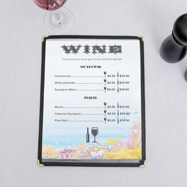 Menu paper with a seafood themed ocean design on a table with a wine glass and wine.