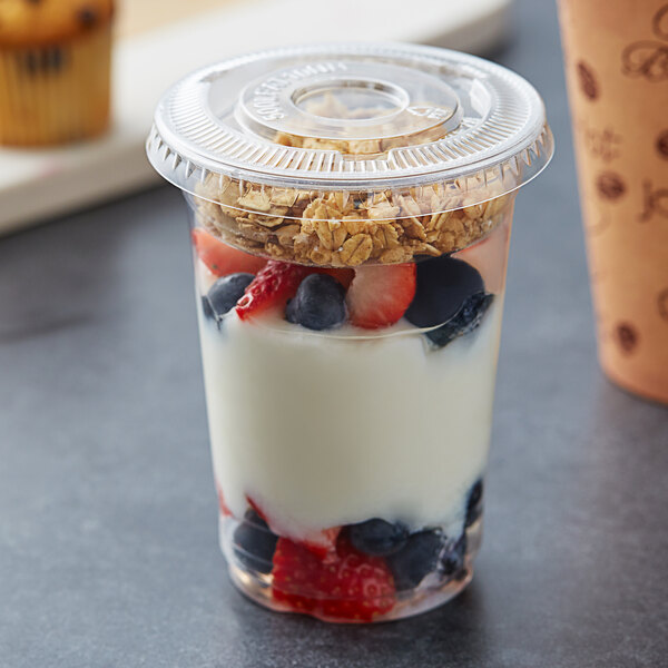 A Choice plastic cup with yogurt, fruit, and cereal in it.