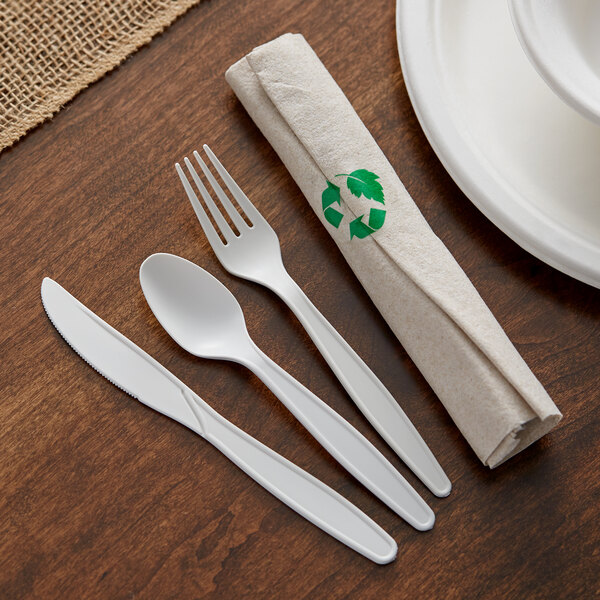 A white napkin with a Hoffmaster CaterWrap white heavy weight plastic fork and knife.