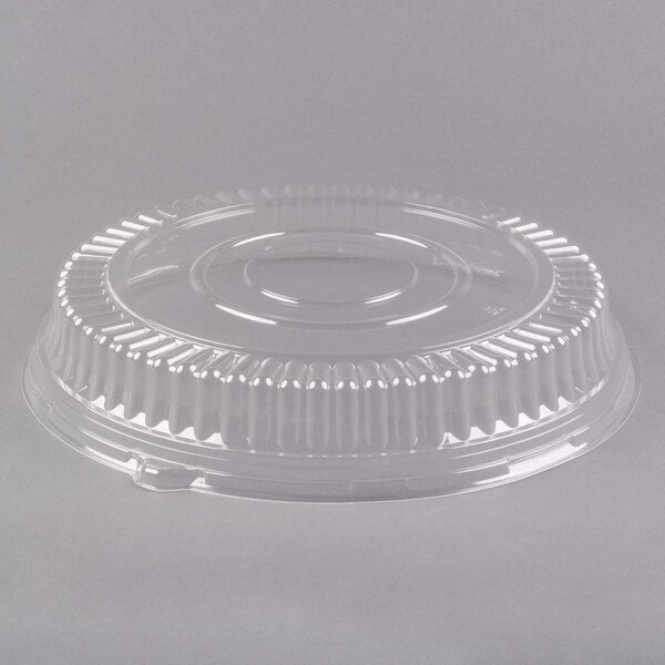 A clear plastic lid for a round catering tray.