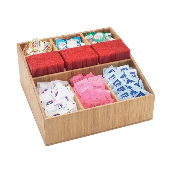 A Cal-Mil bamboo coffee condiment organizer on a table with various condiments in it.