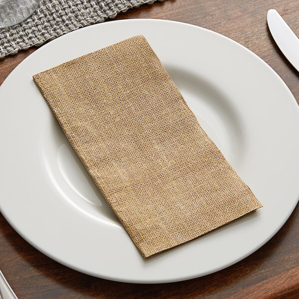A white plate with a Hoffmaster FashnPoint burlap print dinner napkin on it.