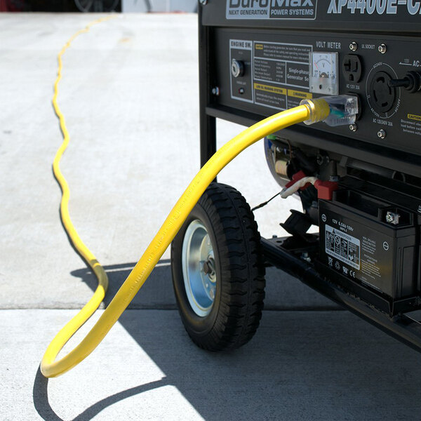 A yellow DuroMax extension cord plugged into a power generator.