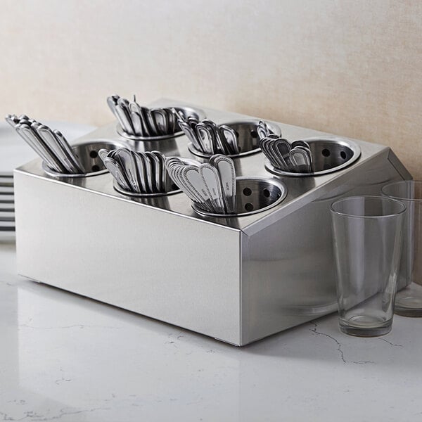 A stainless steel flatware organizer with spoons and forks in it.