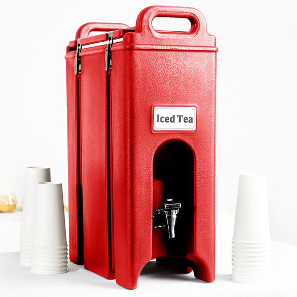 A red Cambro insulated beverage dispenser with a dispenser nozzle and cups.