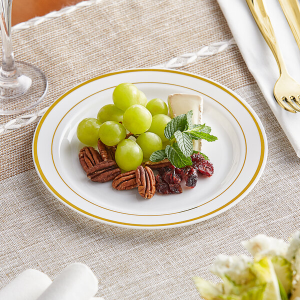 A Visions plastic plate with grapes and pecans on it with a fork.