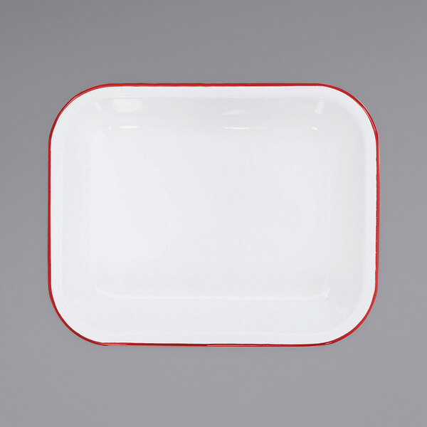 A white enamel roasting pan with a red rim.