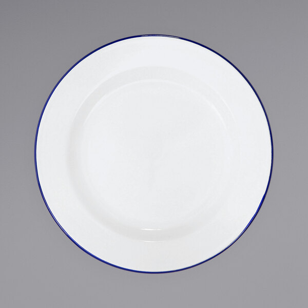 A Crow Canyon Home white enamelware plate with blue rim.