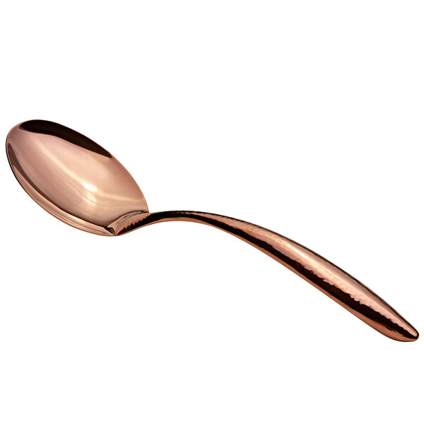 A close-up of a Bon Chef rose gold hammered stainless steel spoon with a hollow handle.