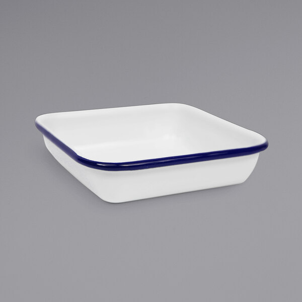 A white square enamelware tray with blue rolled rim.