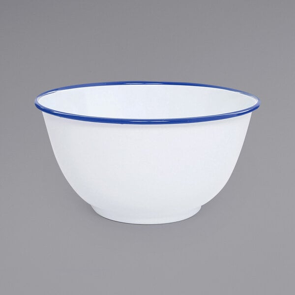 A white Crow Canyon Home enamelware bowl with blue rim.
