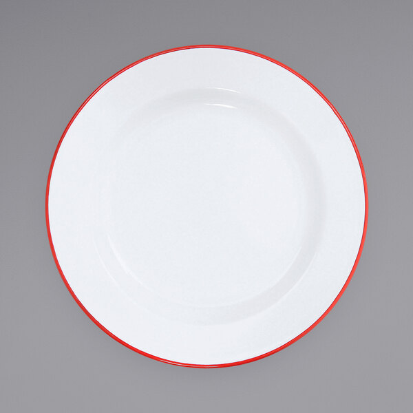 A white Crow Canyon Home enamelware plate with red trim.