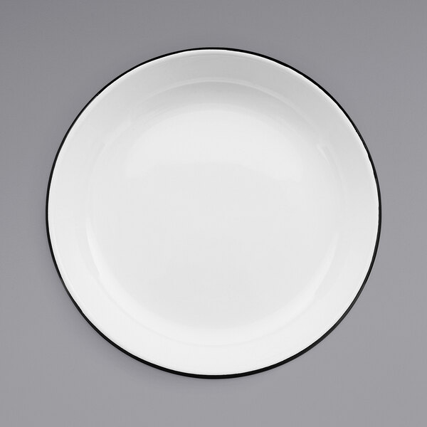 A Crow Canyon Home white enamelware deep coupe pasta plate with black rim.