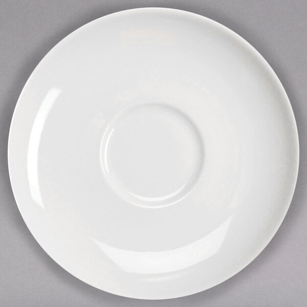 A white Homer Laughlin saucer with a rim on a gray surface.
