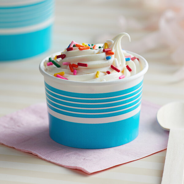A blue and white paper cup filled with ice cream and sprinkles.