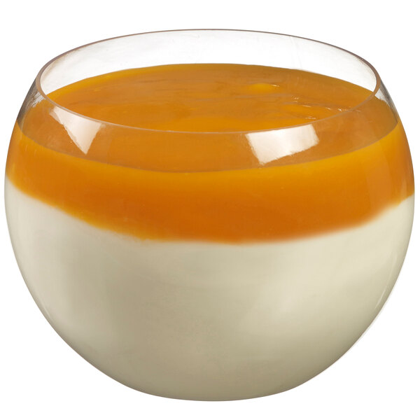 A Solia clear plastic dish with white and orange layered dessert.