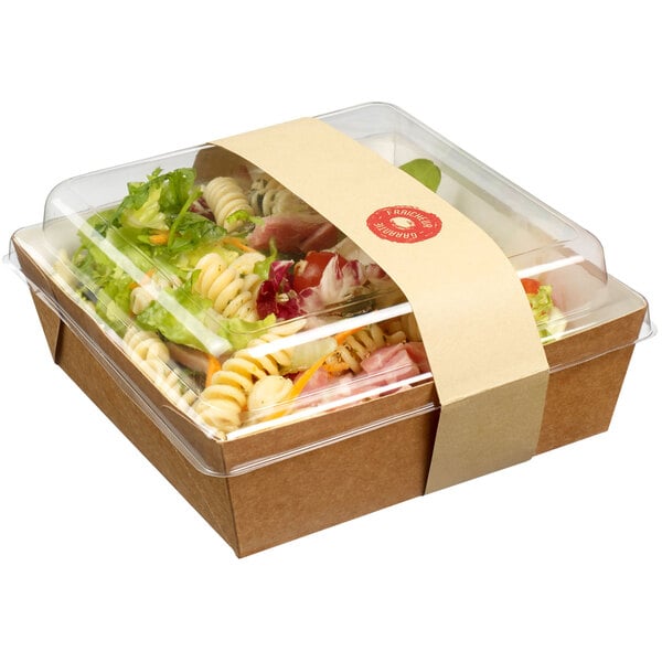 A Solia Kraft salad container filled with salad with a clear plastic lid.