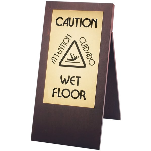 A Cal-Mil dark wood wet floor sign on a stand.