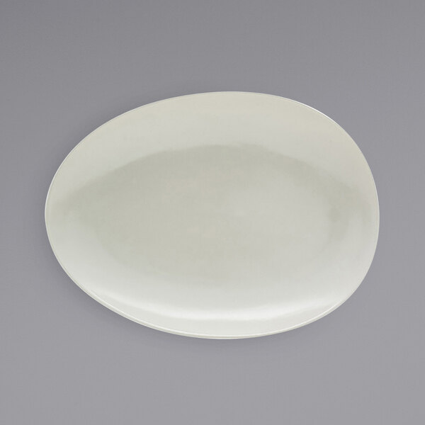 A white oval Front of the House Tides porcelain plate with a circular design.