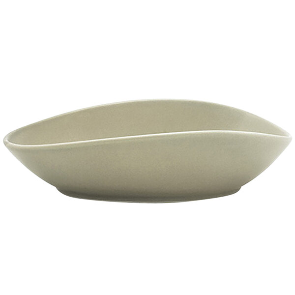 A close-up of a Front of the House Tides semi-matte pumice oval porcelain bowl with a curved edge.