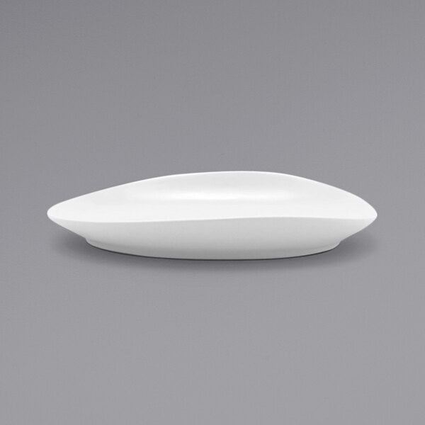 A white Front of the House Tides oval porcelain plate on a gray surface.