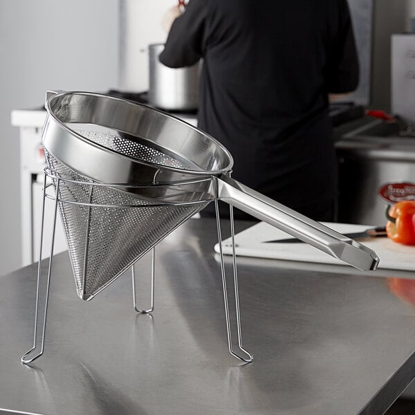 A stainless steel strainer stand on a counter.