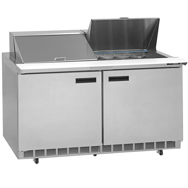 A Delfield stainless steel refrigerated sandwich prep table with 4 drawers open on a counter.