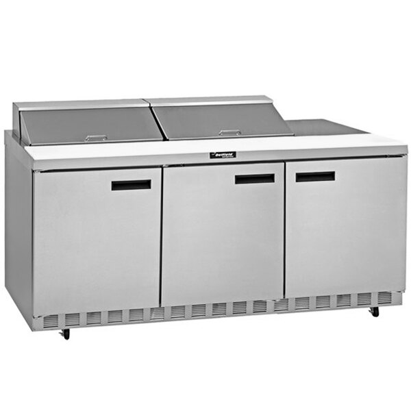 A stainless steel Delfield refrigerator with three doors and a mega top prep table.