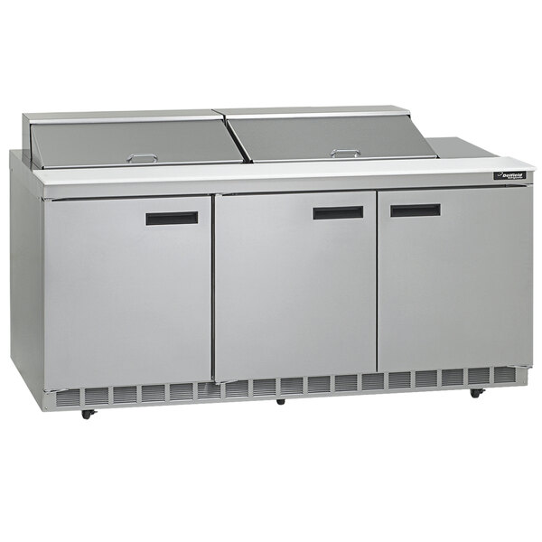 A stainless steel Delfield refrigerated sandwich prep table with three doors on a counter.